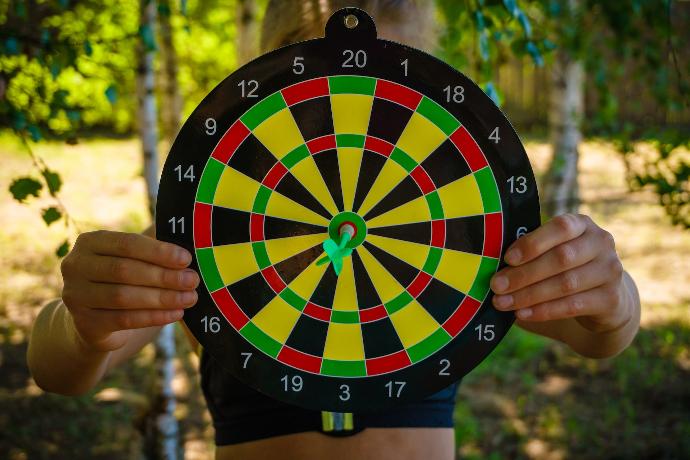 person holding black red yellow and green round analog clock